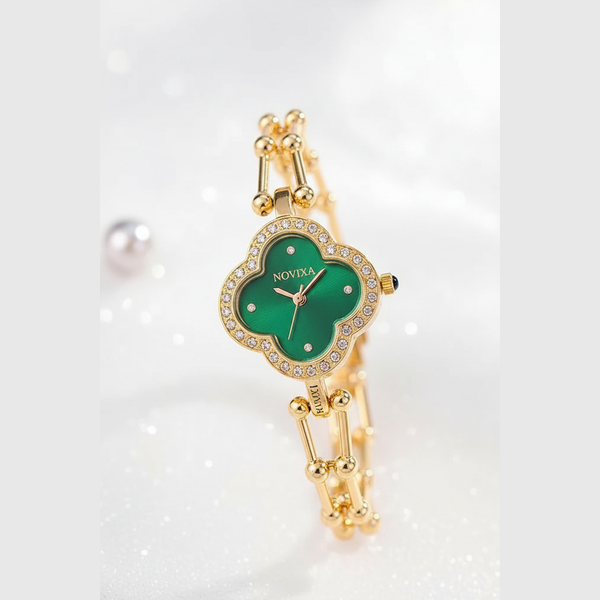 A gold-tone women's watch with a four-leaf clover-shaped dial featuring a vibrant green face and crystal accents, displayed on a sparkling white background.