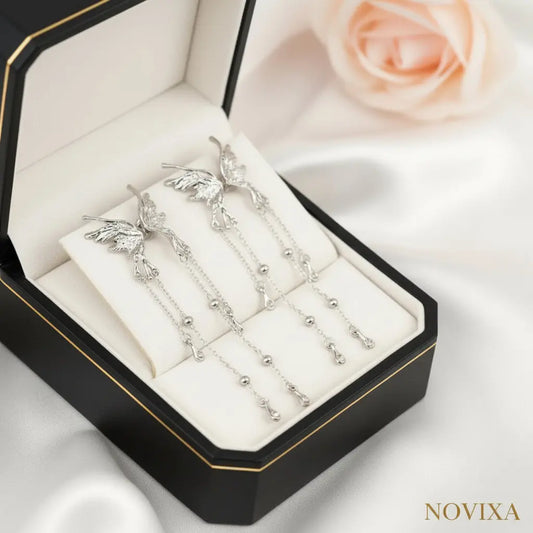 Silver earrings with chain details on a white and beige background